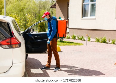 Food Delivery Man In A Protective Mask And Gloves With A Thermo Backpack Near A Car During The Quarantine Period