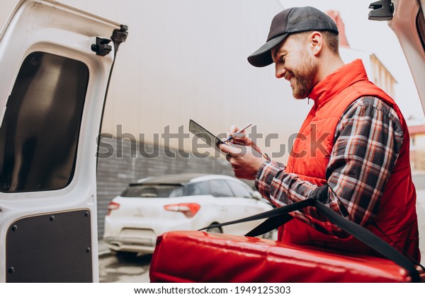 Food delivery\
man putting food box into a\
car