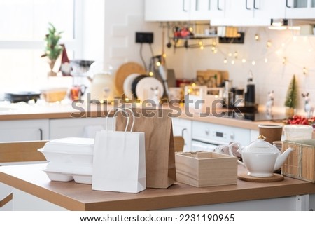 Food delivery service containers on table white scandi festive kitchen in christmas decor. Eve New year, saving time, too lazy to cook, hot order, disposable plastic box in fairy light. mock up