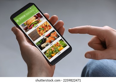 Food delivery service. Man choosing dish from menu on site using smartphone on light grey background, closeup - Shutterstock ID 2259822471