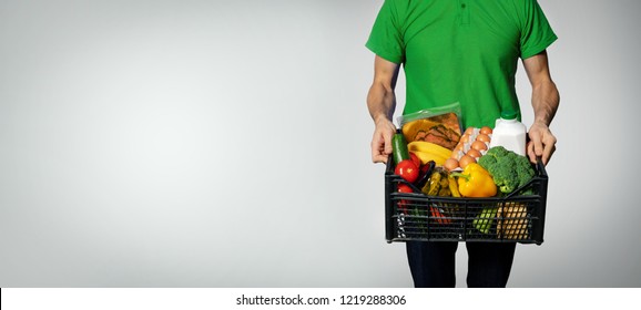 food delivery service - man with groceries box on gray background with copy space - Shutterstock ID 1219288306
