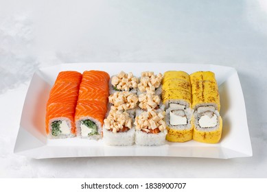 Food Delivery, Takeaway Concept. Lunch Box With Sushi Set. Assorted Sushi, Philadelphia Roll, Cheese, With Squid On White Light Background. Copy Space. Tasty Vegetarian Lunch, Japanese Cuisine Seafood