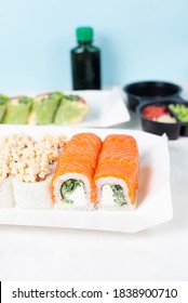 Food Delivery, Takeaway Concept. Lunch Box With Sushi Set. Assorted Sushi, Philadelphia Roll, Cheese, With Squid On White Light Background. Copy Space. Tasty Vegetarian Lunch, Japanese Cuisine Seafood