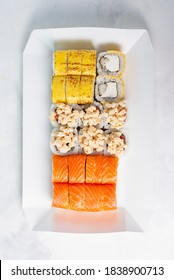 Food Delivery, Takeaway Concept. Lunch Box With Sushi Set. Assorted Sushi, Philadelphia Roll, Cheese, With Squid On White Light Background. Top View. Tasty Vegetarian Lunch, Japanese Cuisine Seafood