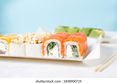 Food Delivery, Takeaway Concept. Lunch Box With Sushi Set. Assorted Sushi, Philadelphia Roll, Cheese, With Squid On White Light Background. Copy Space. Tasty Vegetarian Lunch, Japanese Cuisine Seafood