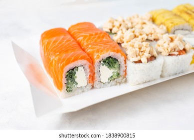 Food Delivery, Takeaway Concept. Lunch Box With Sushi Set. Assorted Sushi, Philadelphia Roll, Cheese, With Squid On White Light Background. Close Up. Tasty Vegetarian Lunch, Japanese Cuisine Seafood