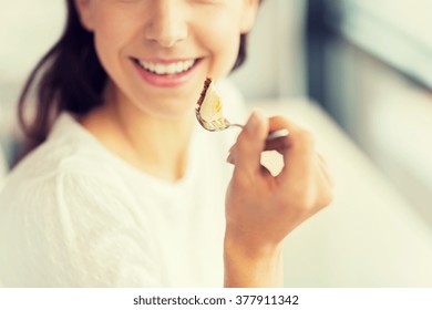 Food, Dessert, People And Lifestyle Concept - Close Up Of Smiling Young Woman Holding Fork And Eating Cake At Cafe Or Home