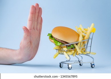 Food And Diet Concept. French Fries And Hamburger For Snack. Fast Food Addiction. Fighting Overweight And Obesity. Refusal Of Junk, Unhealthy Food. Restriction In Carbohydrate Food