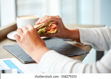 Food, Dinner And People Concept - Woman Eating Salmon Panini Sandwich With Tomatoes And Cheese At Restaurant