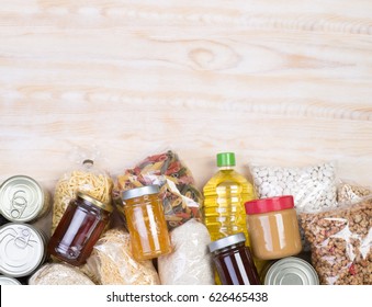 Food donations on wooden background, top view with copy space