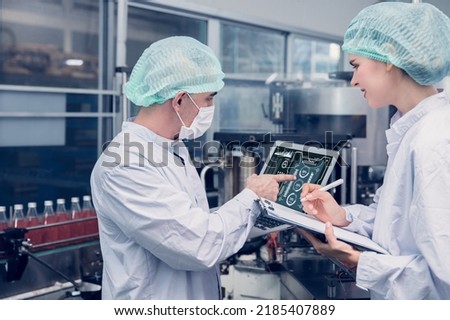 Food and Drink factory worker working together with hygiene monitor control mix ingredients machine with laptop computer