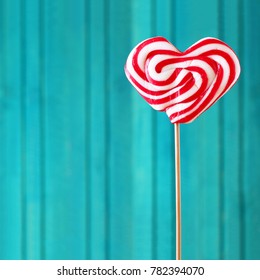 Food and drink, holidays concept. Heart shaped lollipop for love Valentines Day with turquoise background. Copy space