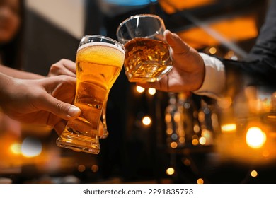 food and drink male friends are happy drinking beer and clinking glasses at a bar or pub. - Shutterstock ID 2291835793