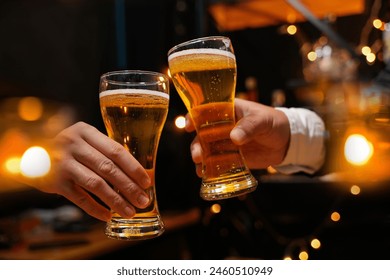 food and drink male friends are happy drinking beer and clinking glasses at a bar or pub. - Powered by Shutterstock