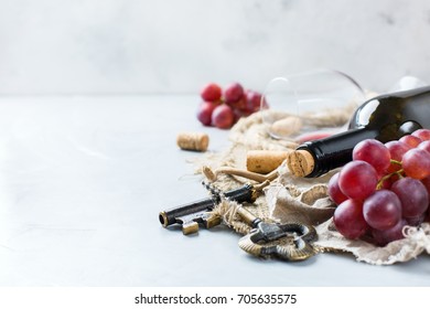 Food And Drink, Still Life, Holidays Seasonal Harvesting Fall Concept. Bottle, Corkscrew, Corks, Glass Of Red Wine And Grapes On A Trendy Concrete Table. Copy Space Background