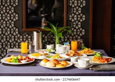Food and drinks served on table for two persons on breakfast or brunch at morning in restaurant. Concept of weekend vacation, rest on holiday in modern city hotel. Dinner or lunch in cafe in resort.