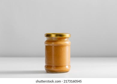 food, eating and preserve concept - close up of jar with canned vegetable puree or peanut butter on table