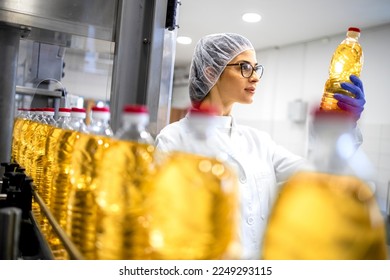 Food factory interior and female worker in sterile uniform and hairnet checking quality of the product. - Powered by Shutterstock