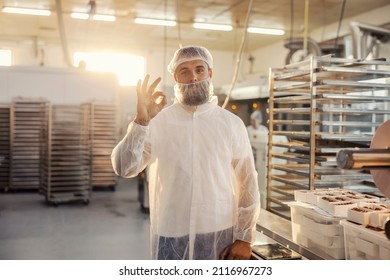 A food factory worker assesses quality of the products with hand gesture.