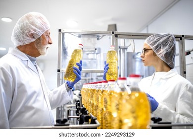 Food factory workers or doing visual quality control of the bottled cooking oil in production plant. - Powered by Shutterstock