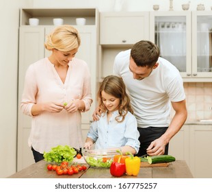 Food, Family, Hapiness And People Concept - Happy Family Making Dinner In Kitchen