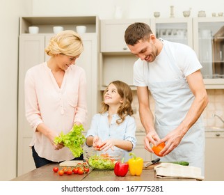 Food, Family, Hapiness And People Concept - Happy Family Making Dinner In Kitchen