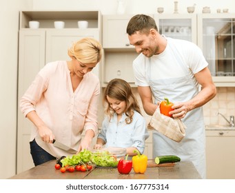 Food, Family, Hapiness And People Concept - Happy Family Making Dinner In Kitchen