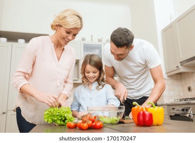 Food, Family, Hapiness And People Concept - Happy Family Making Dinner In Kitchen