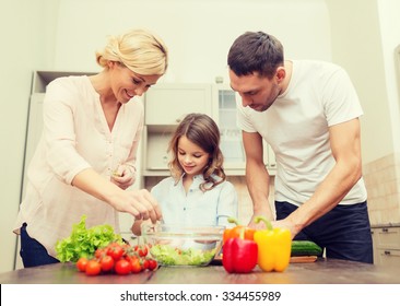 Food, Family, Hapiness And People Concept - Happy Family Making Dinner In Kitchen