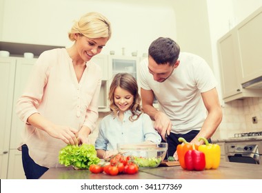 Food, Family, Hapiness And People Concept - Happy Family Making Dinner In Kitchen