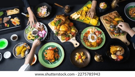Food feast from around the world. Black background. Top angle with many kind of cuisine.
