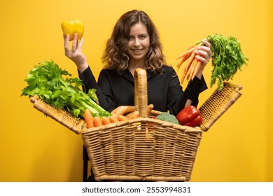 Food fun. Woman holding a picnic basket brimming with fresh fruits and vegetables, radiating health and wellness. The vibrant yellow background enhances the lively, joyful atmosphere of the scene. - Powered by Shutterstock