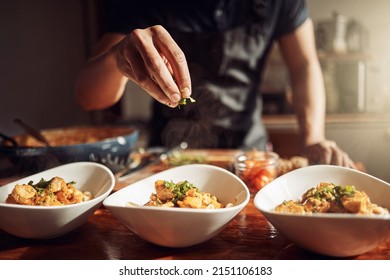 Food as good as the restaurant makes it. Shot of an unrecognisable man preparing a delicious meal at home.