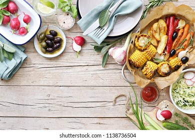 Food Grilled Vegetables Outdoor Table Family Dinner Potato Wedges Roasted Corn Party Picnic. Overhead View, Copy Space