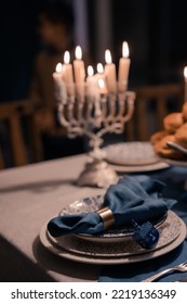 Food For Hanukkah Celebration: Menorah Candles On Wooden Table, Sufganiyot Cake And Table Setting, Jewish Symbol Centerpieces, White And Blue. Holiday Israel Hebrew Traditional Family Celebration