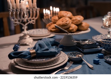 Food For Hanukkah Celebration: Menorah Candles On Wooden Table, Sufganiyot Cake And Table Setting, Jewish Symbol Centerpieces, White And Blue. Holiday Israel Hebrew Traditional Family Celebration