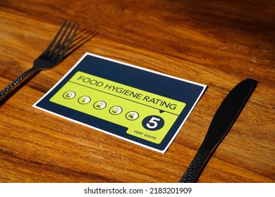 Food Hygiene Rating 5. Very Good Food Hygiene Rating From The United Kingdom Food Standards Agency On Wooden Background.