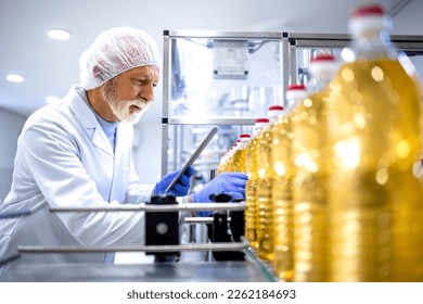 Food industry expert working in vegetable oil bottling factory controlling process of production. - Powered by Shutterstock