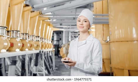 Food Industry Factory Worker Inspecting Production Line Tanker In Of Flour Mill With Computer Tablet.