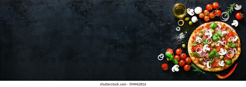 Food ingredients and spices for cooking mushrooms, tomatoes, cheese, onion, oil, pepper, salt, basil, olive and delicious italian pizza on black concrete background. Copyspace. Top view. Banner