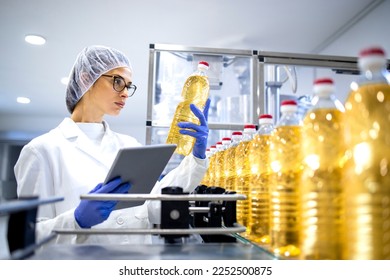 Food inspector or technologist doing quality control of bottled vegetable oil inside bottling plant. - Powered by Shutterstock