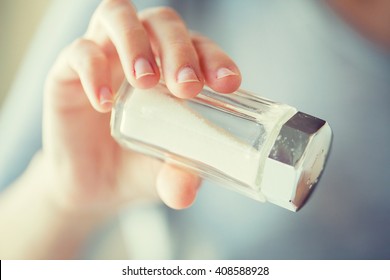 Food, Junk-food, Cooking And Unhealthy Eating Concept - Close Up Of Hand Holding White Salt Cellar