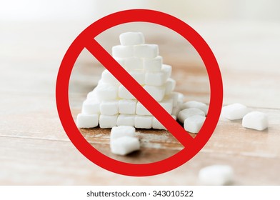 Food, Junk-food, Diet And Unhealthy Eating Concept - Close Up Of White Sugar Pyramid On Wooden Table Over Red Circle-backslash No Sign