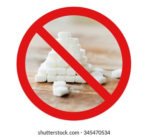 Food, Junk-food, Diet And Unhealthy Eating Concept - Close Up Of White Sugar Pyramid On Wooden Table Over Red Circle-backslash No Sign