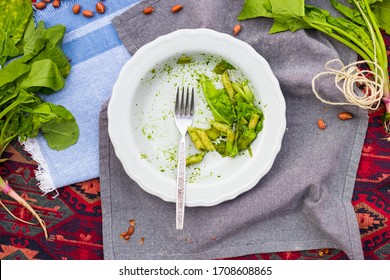 Food Leftovers On Dirty Plated Dish After Vegan Lunch, Dinner Or Breakfast. Finished Meal Of Green Basil Pesto Italian Pasta. Overhead, Flat Lay