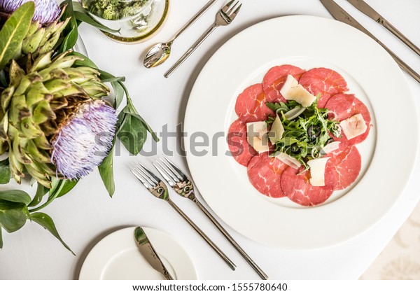 food meal lunch appetizer\
starter carpaccio raw meat elegant gourmet restaurant exclusive\
white cut slice dish snack beef tatar thin fresh table plate red\
dinner