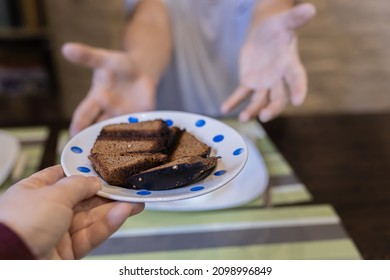 Food Mishaps. Female Hands Hold Out Plate Of Burnt Bread To Man Waiting For Food. Inexperienced Hostess Burned Bread. Burnt Food. Fried Foods Are Unhealthy. Carcinogens In Fried Foods