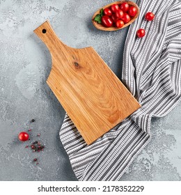 Food mockup. Empty wooden board on concrete table with cooking ingredients. Wooden board  with textile and tomatoes for food menu. Food mockup. Composition with empty place and cooking object