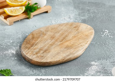 Food mockup. Empty wooden board on concrete table with cooking  ingredients. Wooden board  with fresh lemons and greens for menu. Food menu mockup. Cooking composition with empty place - Powered by Shutterstock