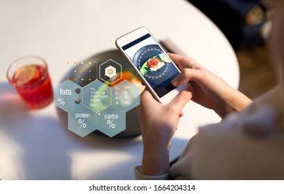 Food, New Nordic Cuisine, Technology And People Concept - Close Up Of Hand With Toast Skagen On Smartphone Screen And Nutritional Value Chart At Restaurant